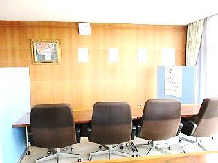 壁に向かって置かれた机と、並ぶ4つの椅子の写真