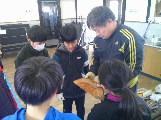 木材を使って製作の指導を受ける子供たち